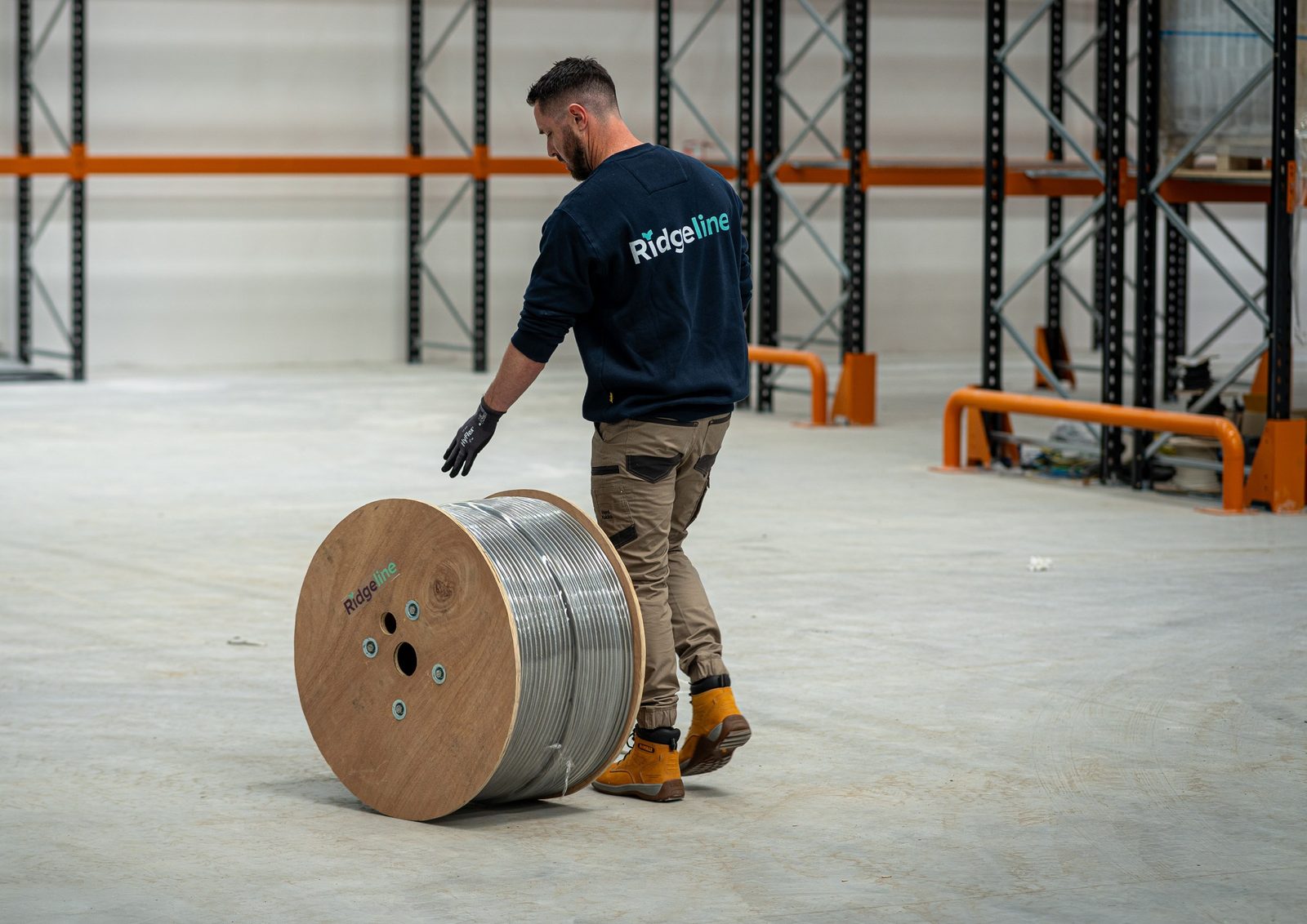 A Ridgeline installer de-spooling corrugated stainless tube in the Vulcan warehouse